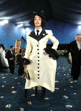 Tessa Thompson – Prabal Gurung: A színésznő úgy vonult végig a Met-gála szőnyegén, mintha egy 1930-as évekbeli noir filmből lépett volna elő – méghozzá modern csavarral. A fekete-fehér színpalettán játszó, férfias szabású kabátruha éppúgy tisztelgés a klasszikus tailoring előtt, mint amennyire avantgárd: túlméretezett gombok, hangsúlyos vállak, fűzős bokacsizma és drámai fekete mandzsetták kísérik az összhatást. A maszkulin-feminin egyensúly tökéletesen rezonál az idei tematika üzenetével: identitás, kifejezés és stílus határok nélkül.