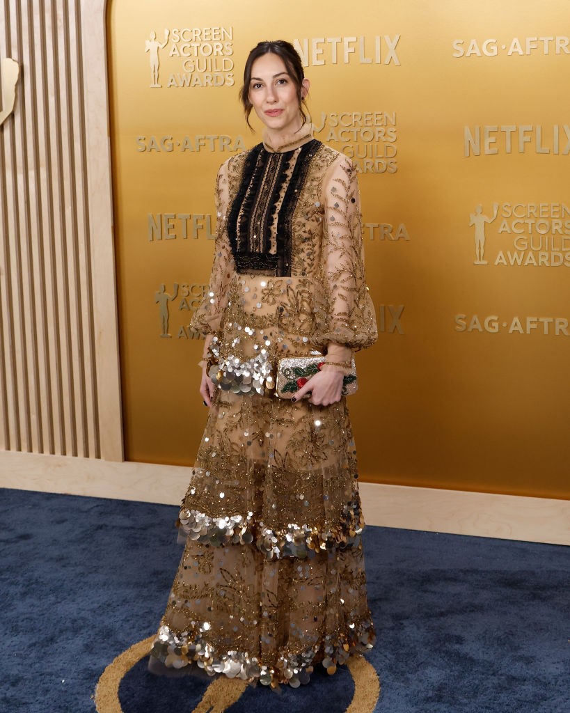 Gia Coppola rendező egy arany és fekete színű, fodrokkal és flitterekkel díszített Valentino ruhában jelent meg. A ruha réteges kialakítása és a különböző textúrák kombinációja figyelemfelkeltő megjelenést kölcsönzött számára. Bár a szett egyesek szerint kissé túlzsúfoltnak tűnt a vörös szőnyegen, különösen a háttér arany színével szemben, Coppola választása mindenképpen emlékezetes és egyedi volt. 