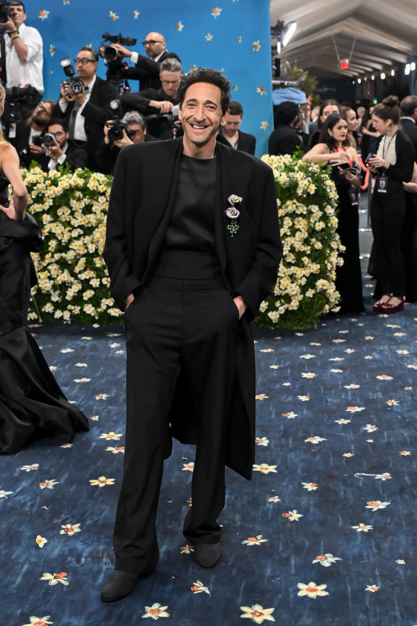  Az Oscar-díjas Adrien Brody egy virágos brossal csipetnyi könnyedséget kölcsönzött Fear of God selyem összeállításának. Ez a megjelenés egyszerre volt nagyon modern és nagyon elegáns.