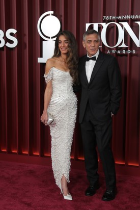 Amal Clooney az idei Tony-gálára egy testhez simuló, hófehér Tamara Ralph kreációt viselt fűzőszerű, vállvillantós felsőrésszel, amit különböző méretű gyöngyök borítottak. 