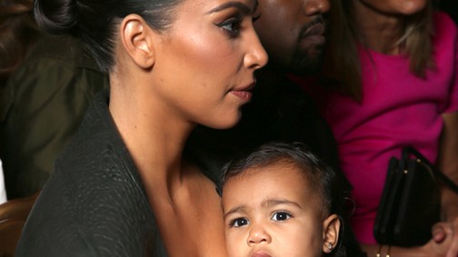 North West  Kim Kardashian óriási mellei közül figyeli a show-t