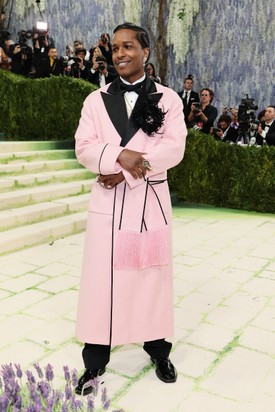 A$AP Rocky nagyon elegánsan festett a rózsaszín Chanel-szettben, amely Matthieu Blazy egyedi tervezése. A rapper egy rózsaszín gyapjúköntöst viselt fekete szatén hajtókával és fekete szegéllyel, amelyet egy tollas bross díszített. 