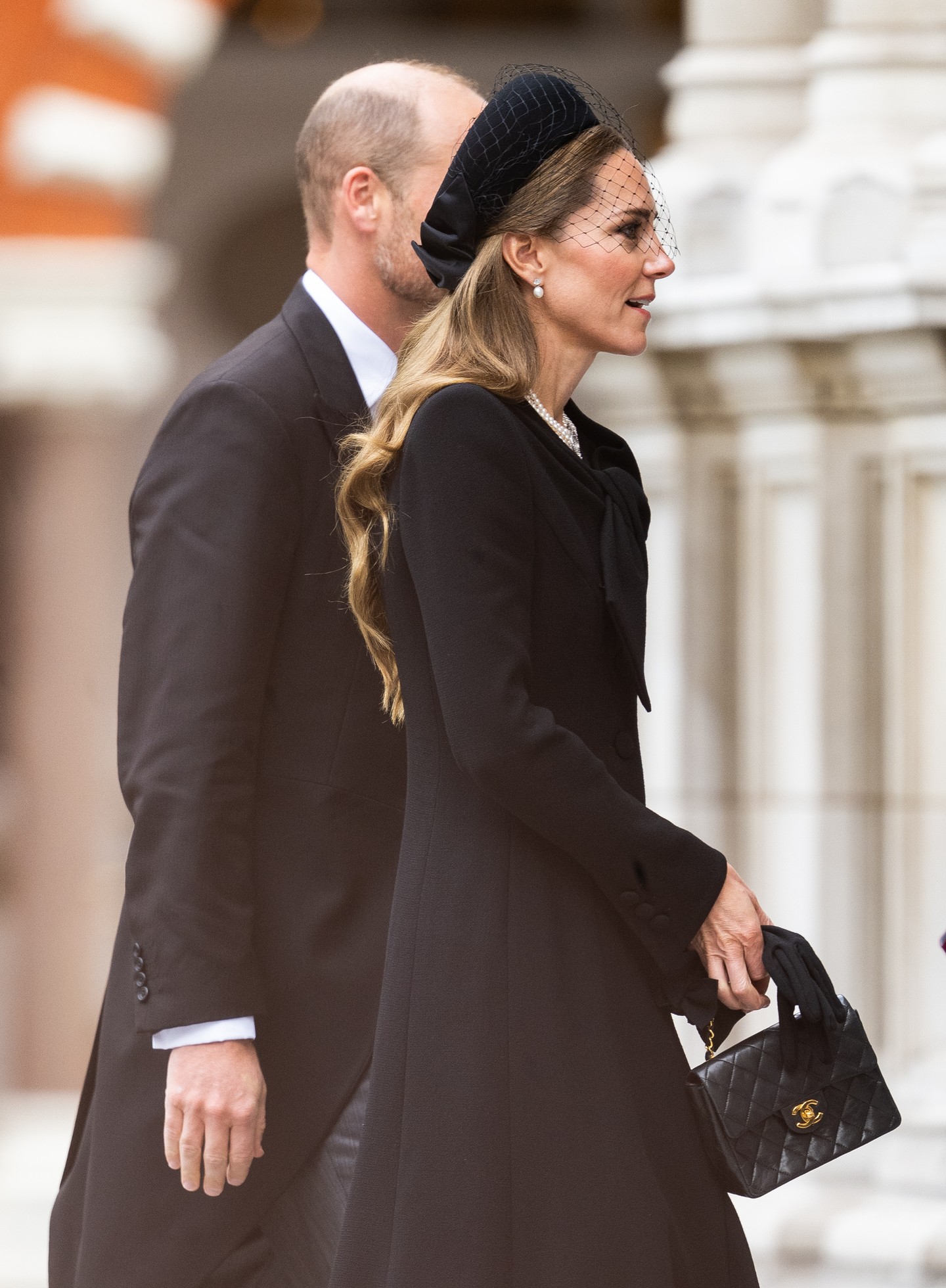 Ezt a Catherine Walker kabátot nem először láthatjuk Katalin hercegnén. A  letisztult darabot egy Jane Taylor-féle pillbox kalappal párosította, amelyen egy finom fátyol is helyet kapott. A klasszikus megjelenést a tökéletes Chanel táska tette teljessé.