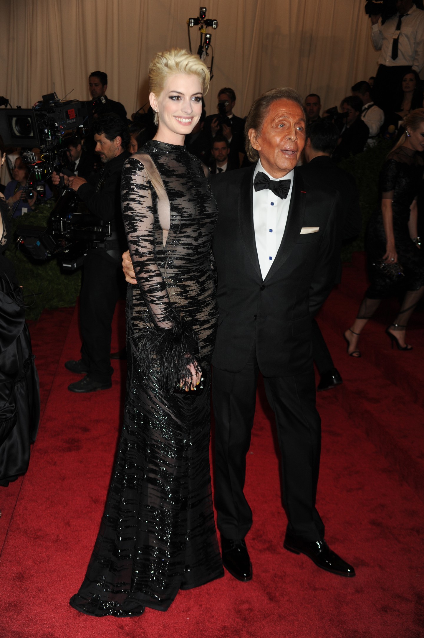 Anne Hathaway teljesen átadta magát a 2013-as Met-gála punk témájának, exhibicionista oldalát megmutatva ebben a Valentino Couture díszes, tollas mandzsettákkal ékesített vintage ruhában. A tervezés azért is érdekes, mert a kifinomultság és a vadság egyszerre van jelen benne.