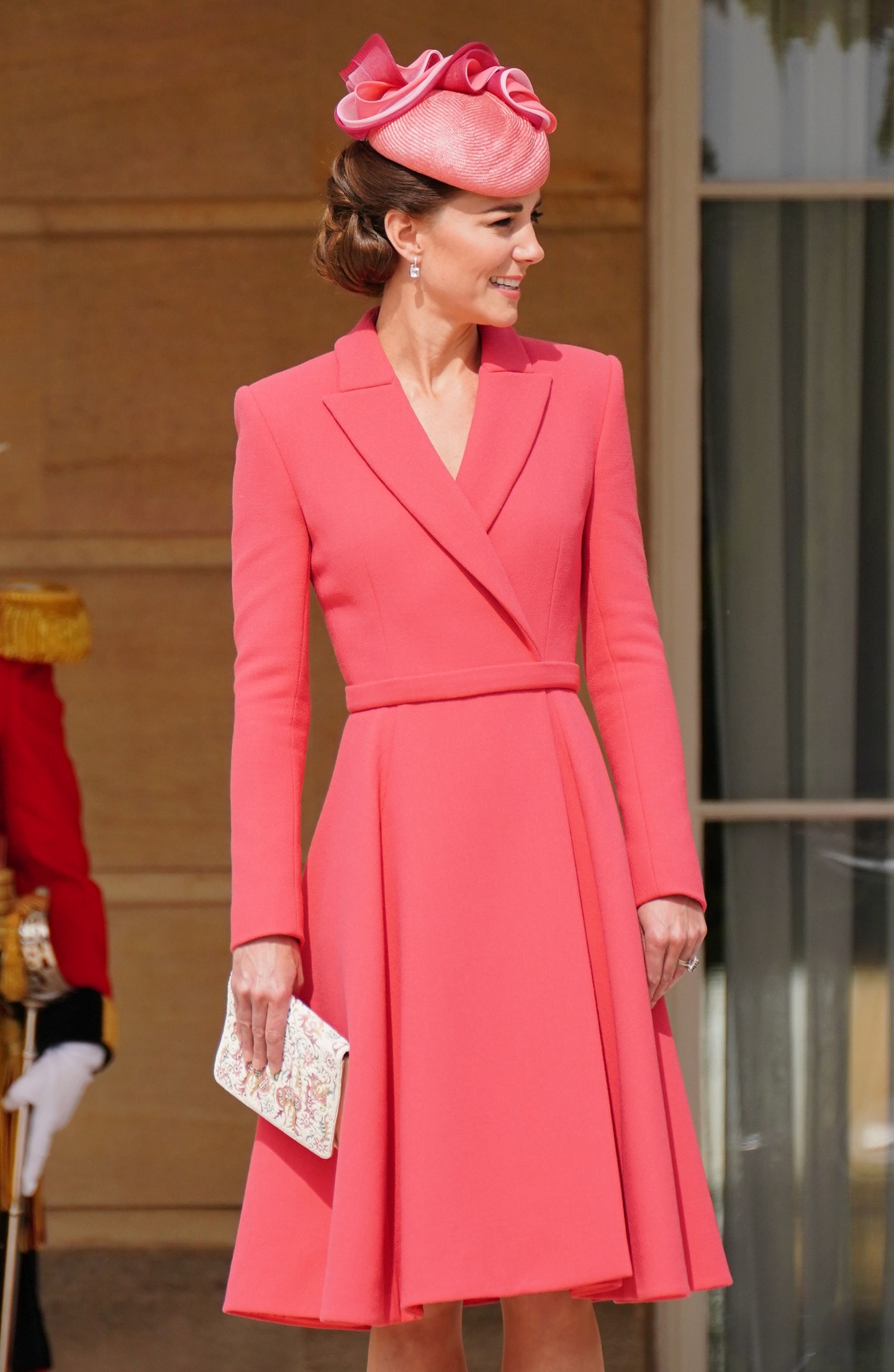 Katalin hercegné ebben a szettjében tényleg úgy festett, akár egy elegáns Barbie baba. 2022 májusában a Buckingham-palota kerti partiján egy korallszínű kabátruhában tűnt fel, a megjelenését egy aprócska kalappal valamint rózsaszínű velúr cipővel egészítette ki. 