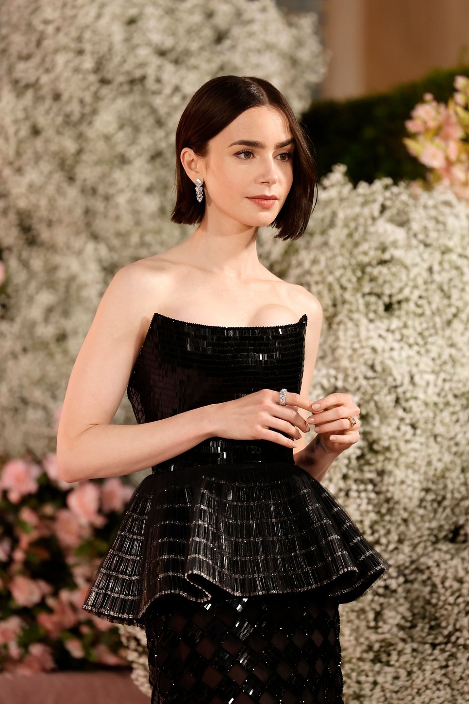 Lily Collins a Cartier Reflection 18 karátos fehér aranyból készült, gyémántokkal körülölelt fülbevalóját és gyűrűjét viseli