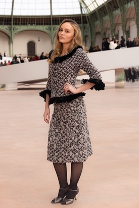 Lily-Rose Depp egy fekete-fehér-rózsaszín, tollakkal díszített tweed blézer és egy hozzá passzoló, térdig érő szoknya mellett tette le a voksát. 