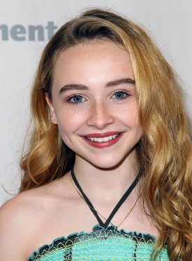 Bájos tinédzserként fülig érő szájjal mosolyog egy hollywoodi eseményen 2014-ben. 