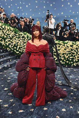 Alicia Keys – Moncler: Az énekesnő nem csupán belebújt egy öltönybe, hanem újra is gondolta. A vörös és sötétkék csíkos, túlméretezett Moncler szett egyszerre idézi a klasszikus dandy stílust és formabontóan írja újra a szabászat szabályait. A puffos ujjakból épített drámai uszály futurisztikus eleganciát csempész az összeállításba, miközben a flitteres, gyöngyökkel díszített hajdísz koronaként zárja a látványt. Keys megjelenése szó szerint és átvitt értelemben is súlyt ad a tailoring új definíciójának.