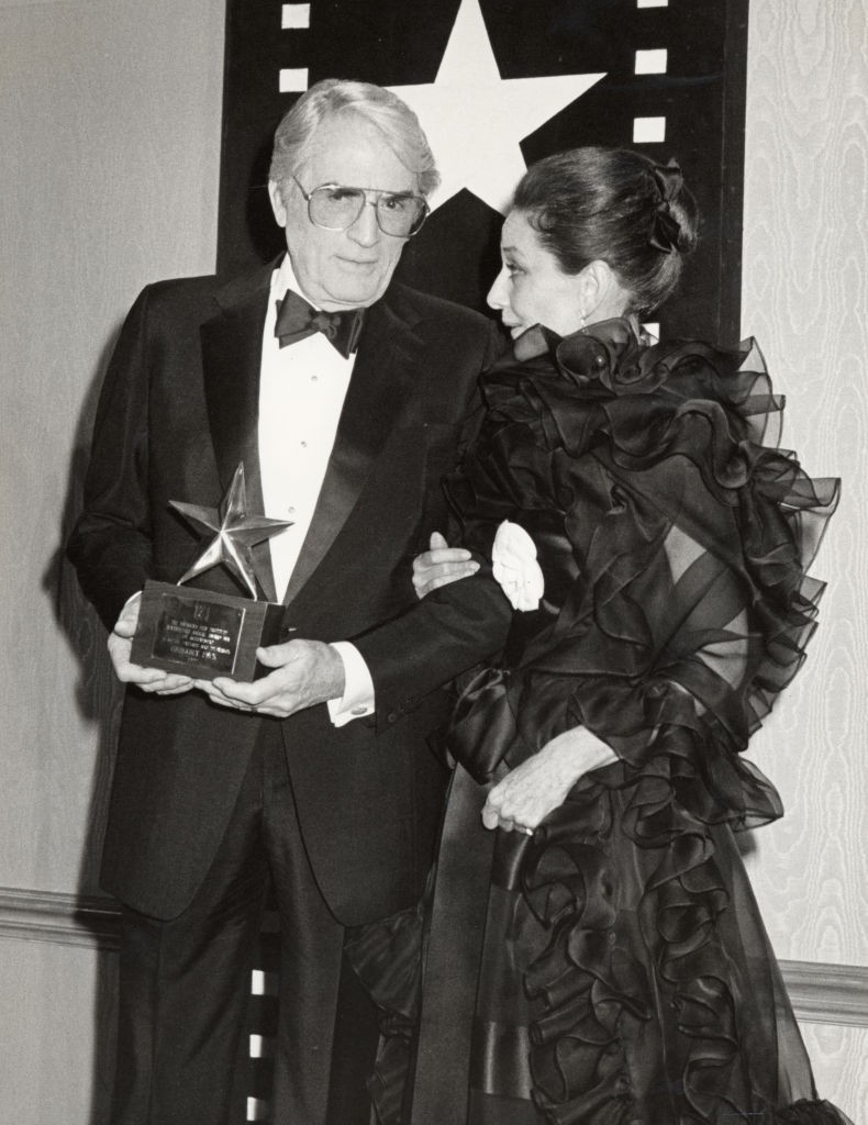 Gregory Peck és Audrey Hepburn újra együtt, ezúttal nem filmen, hanem az életben – 1989-ben az American Film Institute gáláján találkoztak, amikor Peck életműdíjat vehetett át. Hepburn gyönyörű, fodros estélyiben kísérte színpadra egykori partnerét, akivel a Római vakáció című film óta összeforrt a nevük.
