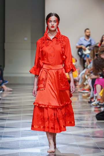 A Romani Design 2023-as tavszi-nyári kollekciójában a piros alapon a piros szalagok, díszítések csillogása izgalmassá teszi a nagyon vidám öltözékeket