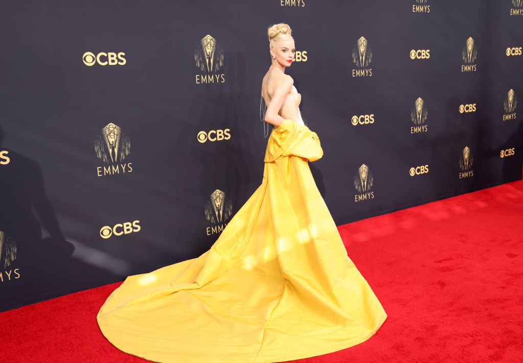A Vezércsel sztárja egyenesen a 20-as évek eleganciáját hozta el a 2021-es gálára ebben a sárga, selyem-drapírozott Dior Haute Couture estélyiben. A kreációt egy drámai, földig érő, krémszínű selyemköpeny tette még fenségessebbá. A magasan feltűzött szőke konty és a rubinvörös ajkak egy modern hercegnő benyomását keltették Anya-Taylor Joy személyében.