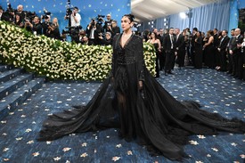 Az énekesnő egy fekete flitteres tweed kabátban és egy organza köpenyben érkezett. A teljes megjelenés elkészítése összesen 2000 órát vett igénybe, és 45 000 hímzett elemet tartalmaz, kiemelve a kézműves munka figyelemre méltó színvonalát és fontosságát