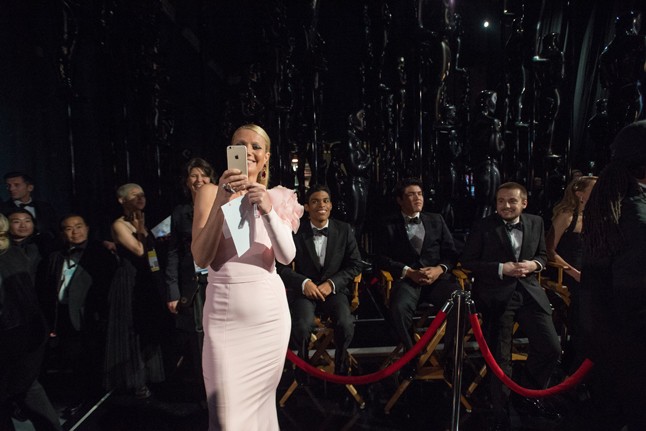 Kitűnő fotó a fekete-fehér öltönyös férfiak között a rózsás Gwyneth Paltrow-ról.