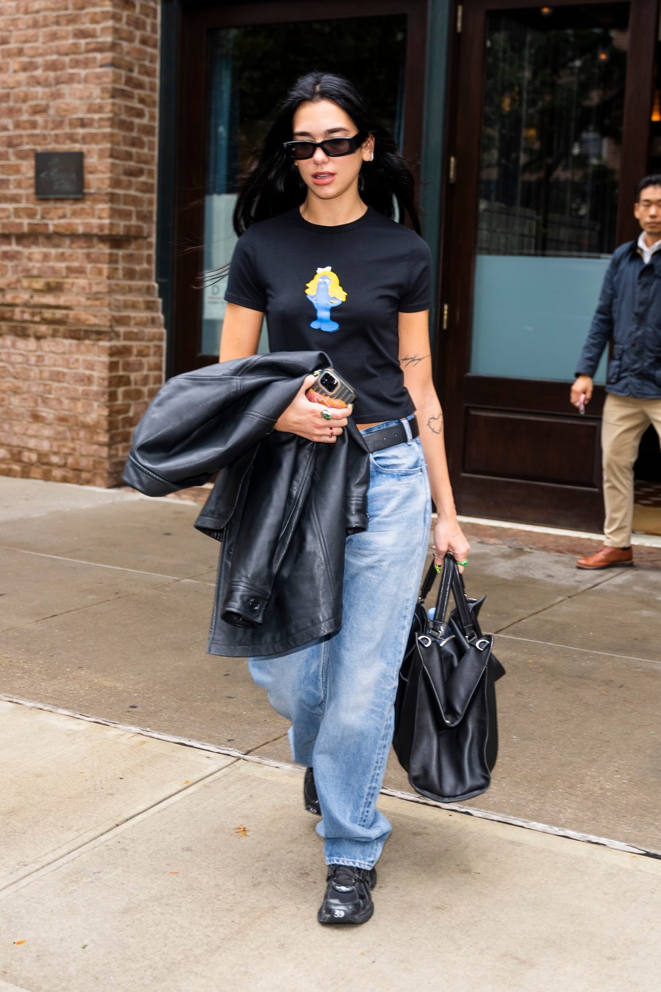 A bő farmert, amelyet Dua Lipa egy nem kevésbé egyszerű pólóval viselt a kiegészítők tesznek teljessé