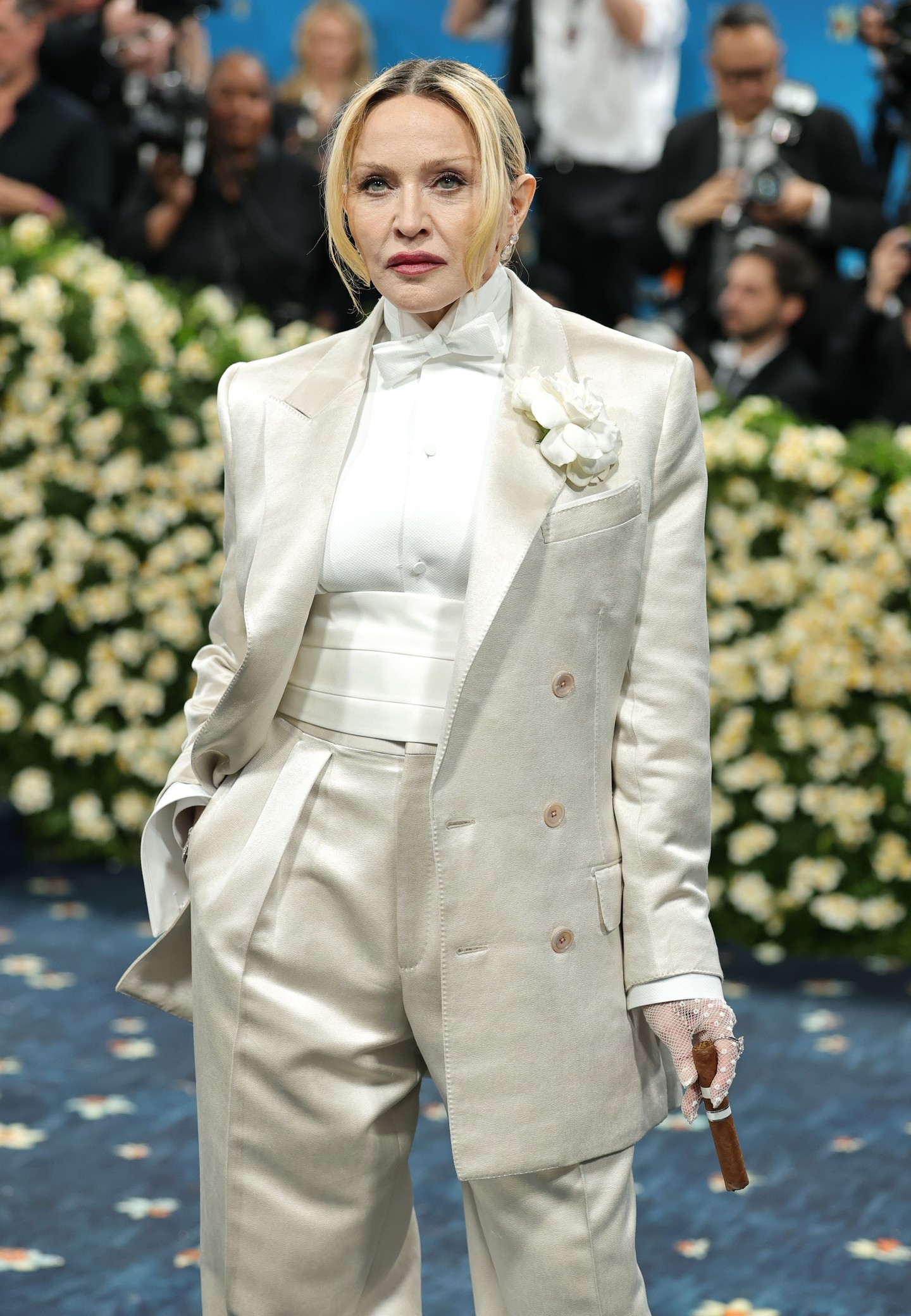 Tökéletesen szabott nadrág, hozzá illő testhezálló blézer és ropogós fehér ing, kiegészítve a legstílusosabb részletekkel, mint a csokornyakkendő és a horgolt kesztyű