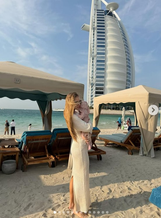 Vízparti pihenés Dubajban: Buzsik Borka a Jumeirah strandon, háttérben a jellegzetes Burj Al Arab luxusszállodával. A felvétel a család közel-keleti utazásának egyik kötetlen, tengerparti pillanatát örökíti meg.