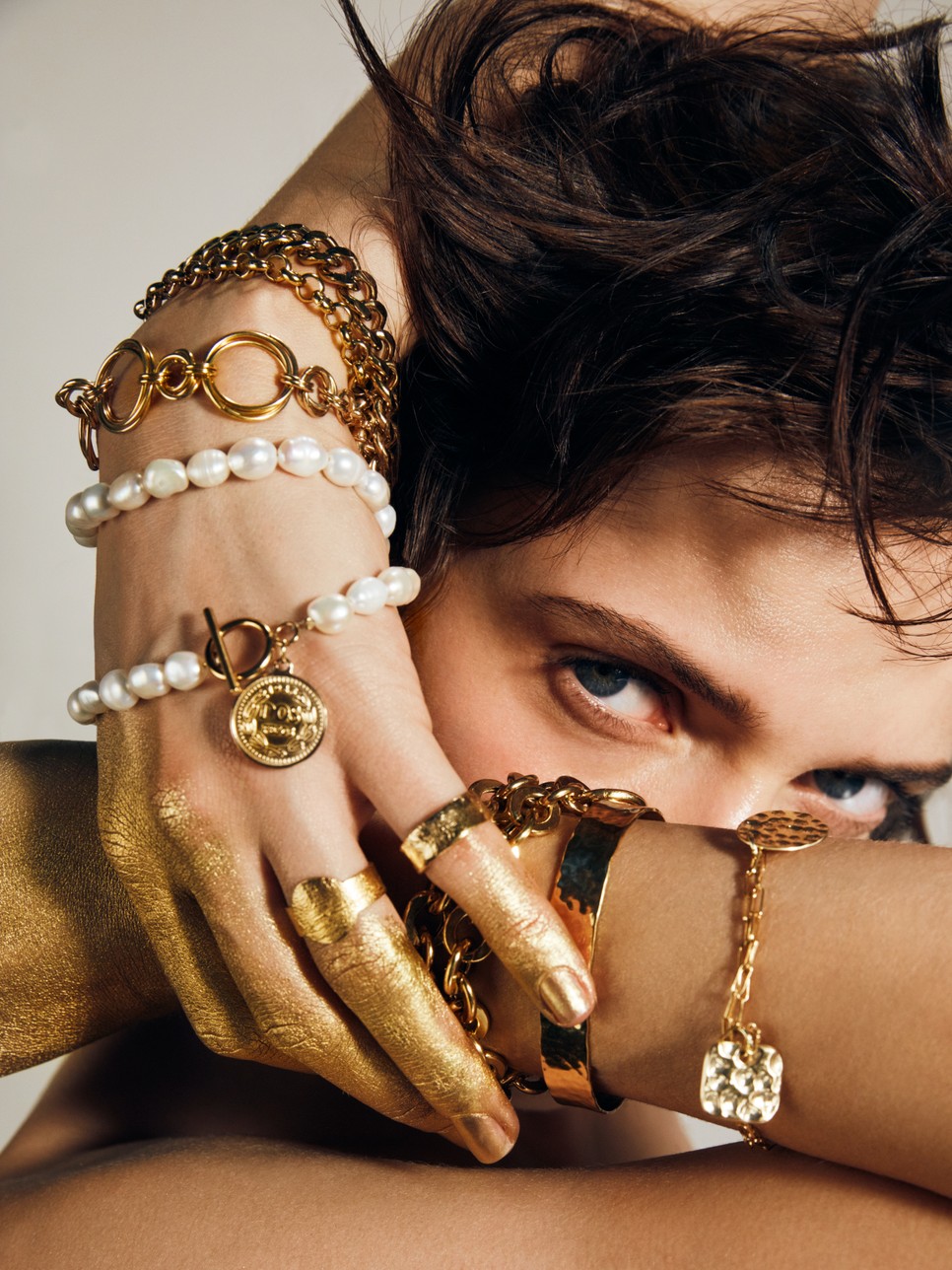 Bal kéz: arany színű nyaklánc karkötőként UMIAR, Pénzérmés gyöngysor karkötőként KLARA KOSTRZEWSKA, Gyűrűk EWA WISNIEWSKA Jobb kéz: Karkötő elemekkel, merev és láncos karkötő UMIAR 